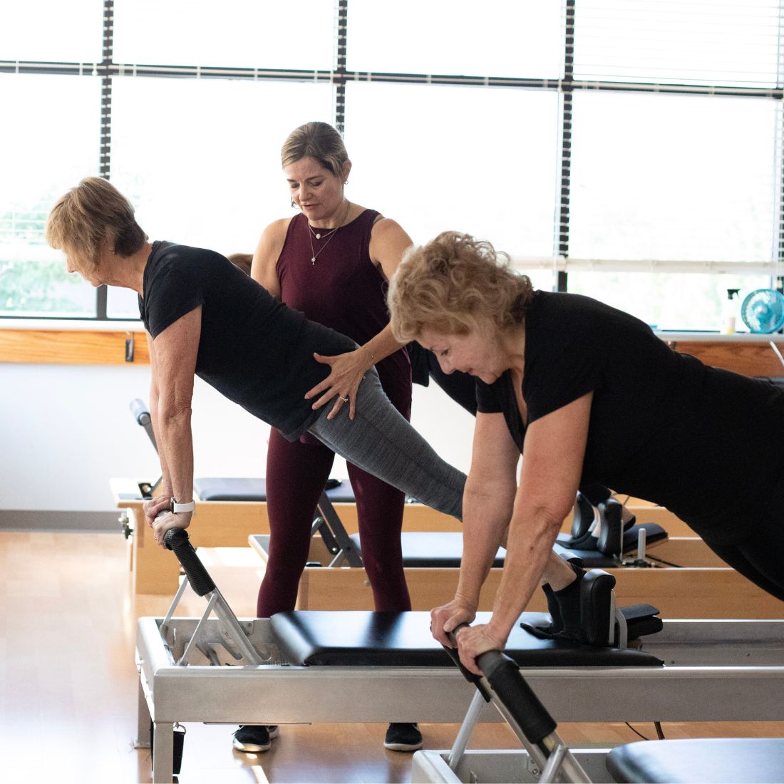 Karen Wilder, classical Pilates instructor, is teaching a client during a Reformer lesson.