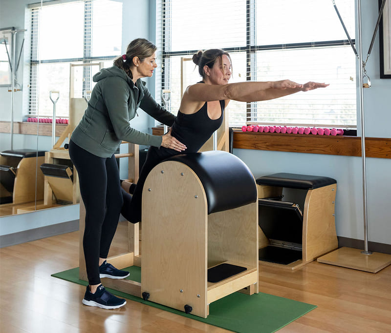 private-pilates-session-kansas-city Pilates instructor teaching a private lesson in a classical Pilates studio near Kansas City KS